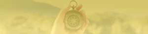 Hand holding vintage compass over blurred landscape